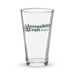 Pint glass with the Accessibility Craft podcast logo, which includes an alligator wearing a t-shirt with "a11y" on it with a laptop and beer glass.