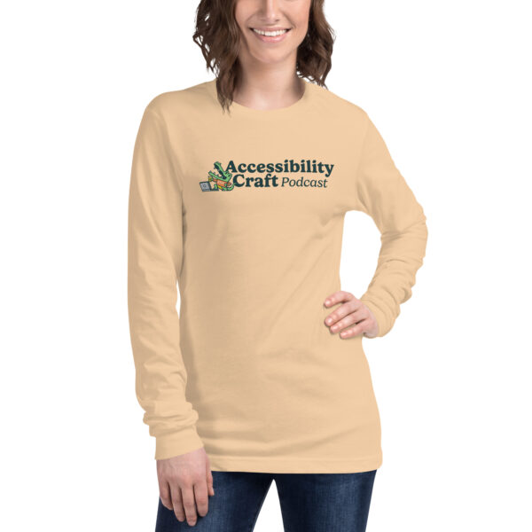 Woman wearing a sand-colored long-sleeve Accessibility Craft podcast t-shirt.